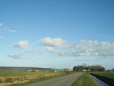 Glastuinbouw, windturbines en kop-hals-rompboerderij.